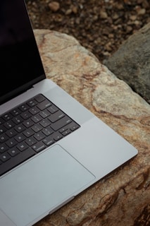 An artistic shot of a Peridot gem crystal beside a laptop, symbolizing the brand’s inspiration and creativity.