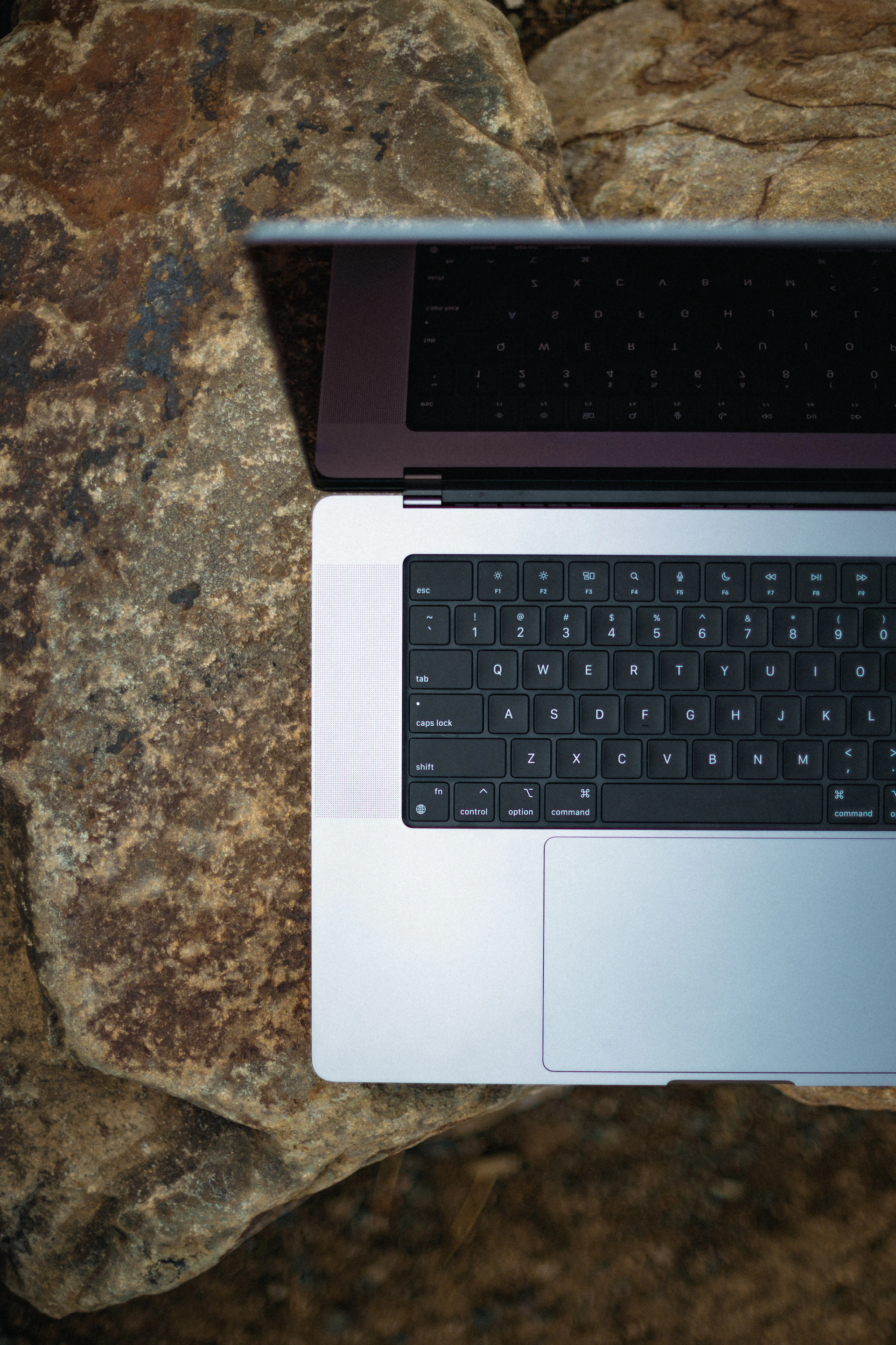 An elegant business workspace featuring a laptop with the granitepulse website open, surrounded by natural stone textures and warm lighting.