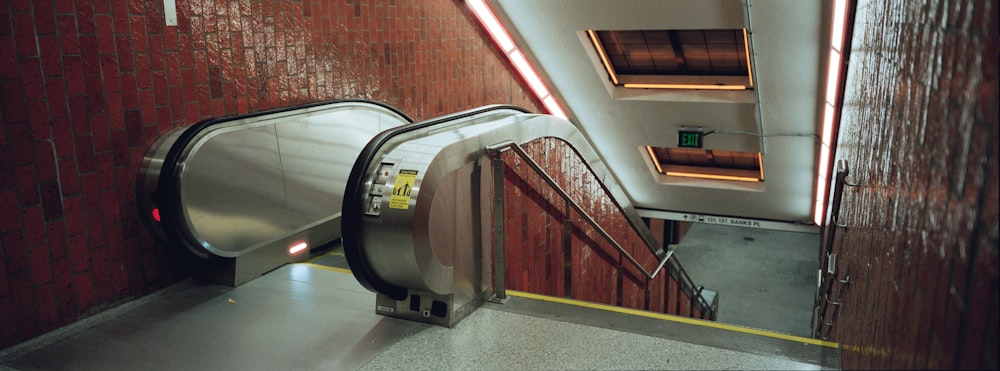 an escalator in a subway station with red brick walls