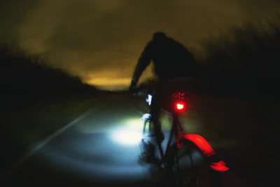 a man riding a bike down a street at night