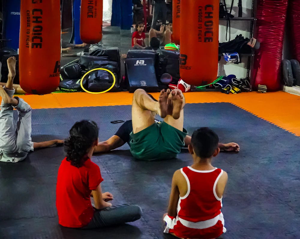 Children sitting on the mats listening to their coach