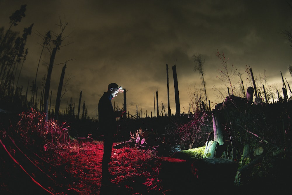 a man standing in a field at night