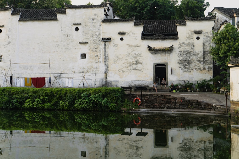 an old building with a pond in front of it