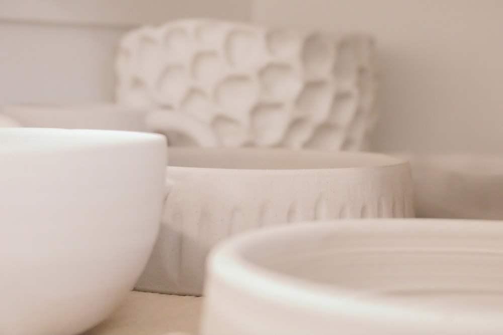 a close up of some white bowls on a table