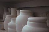 a row of white vases sitting next to each other