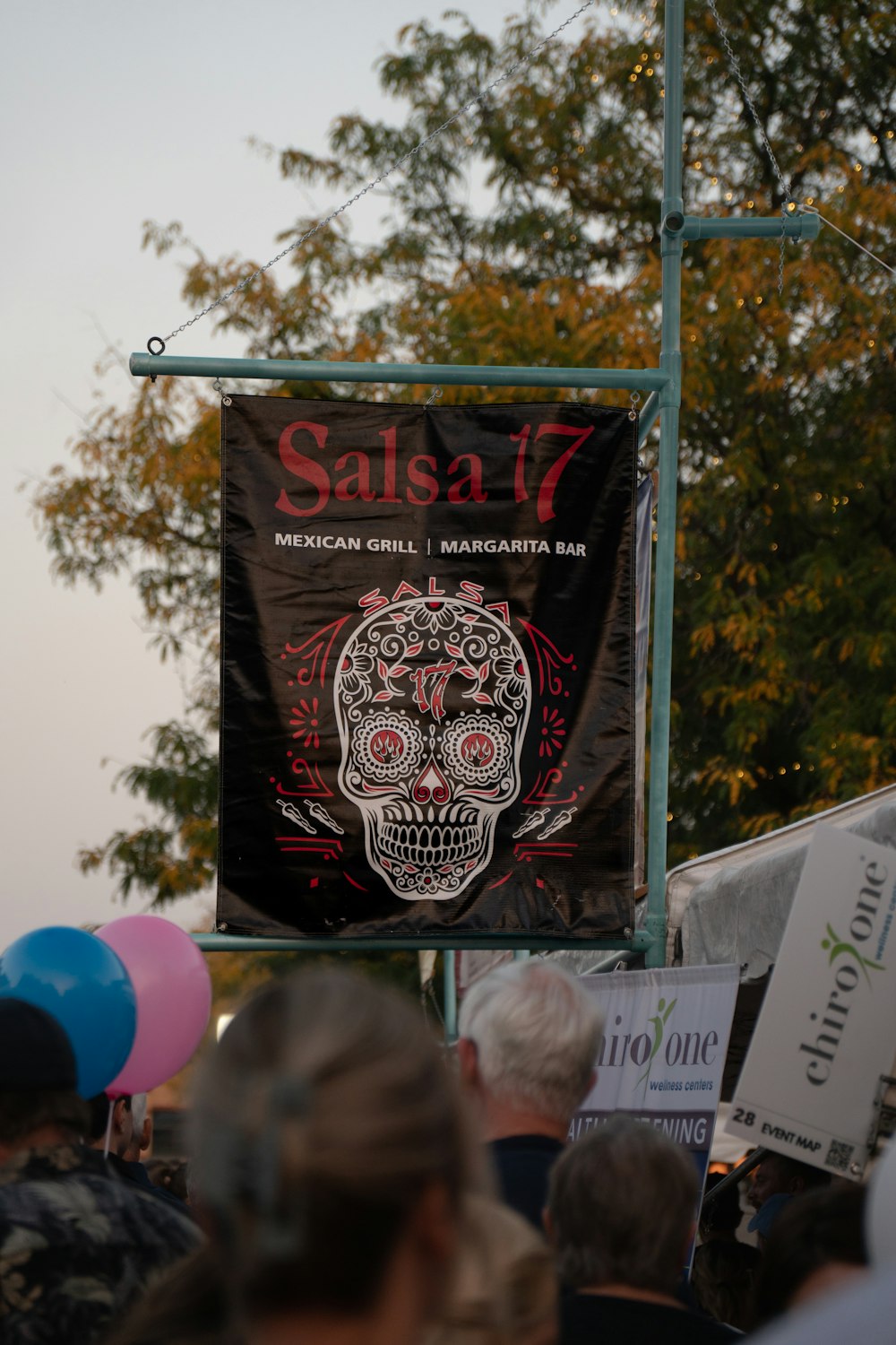 a group of people walking down a street next to a sign