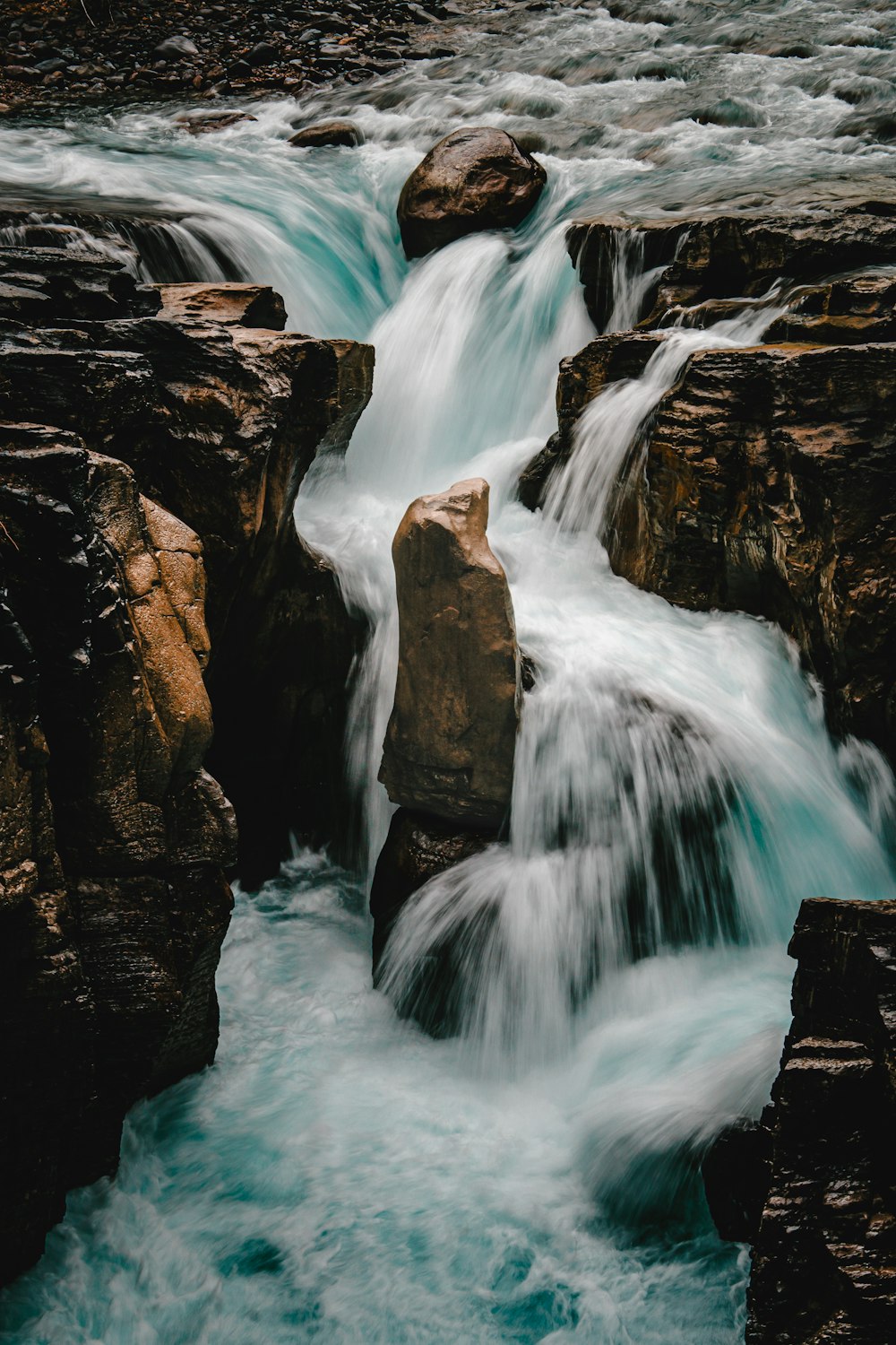 a small waterfall flowing over rocks into a river