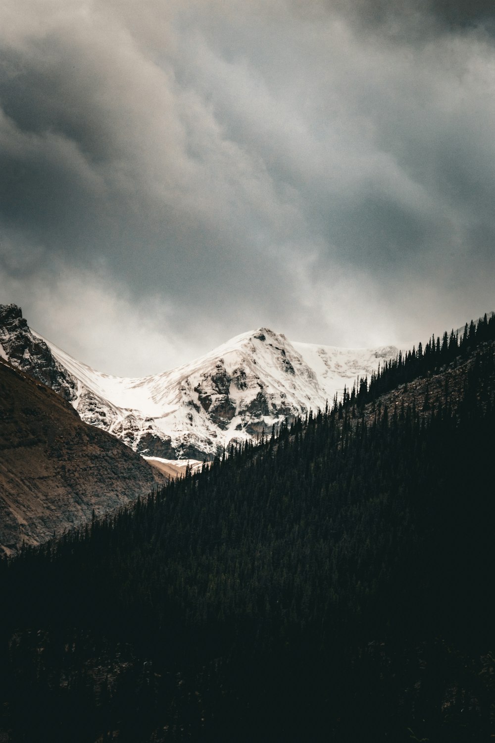 a snow covered mountain under a cloudy sky