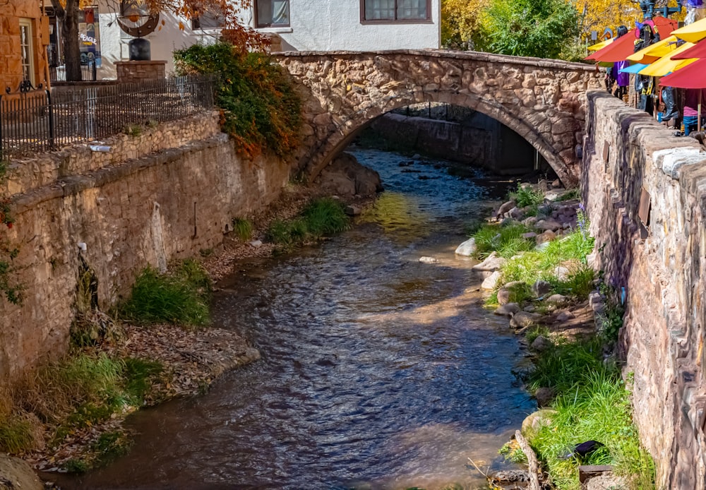 a stone bridge over a small river in a small town