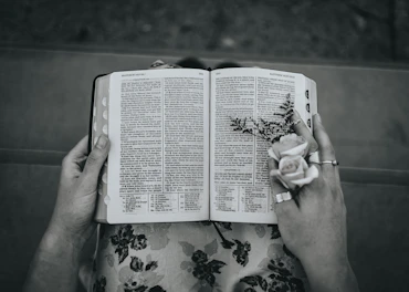 a person holding a book with a flower on it