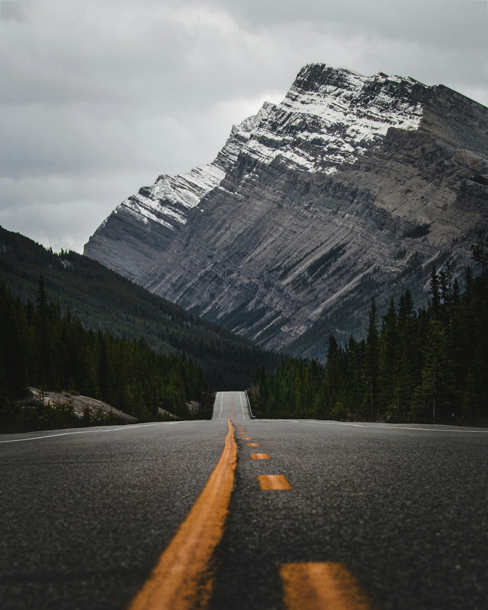 an empty road with a mountain in the background