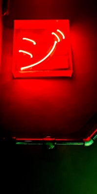 A neon-blue smiling human face icon glowing against a dark futuristic cityscape.