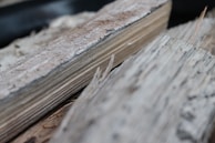 Artisan selecting small pieces of reclaimed wood laid out on a rustic wooden table.