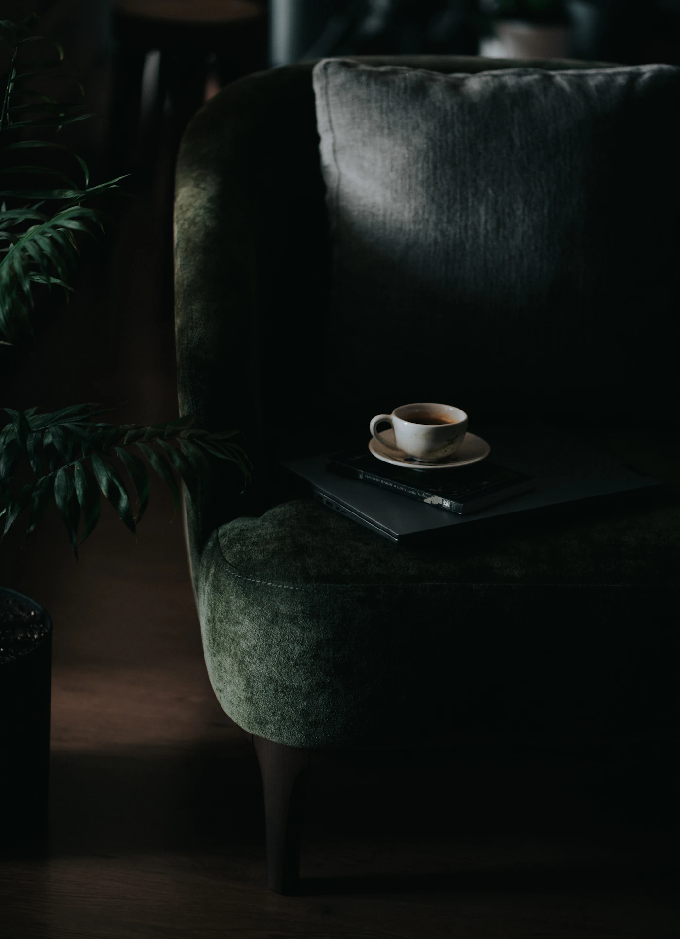 Still-life corner in near darkness with a hat resting on a chair (placeholder photograph)
