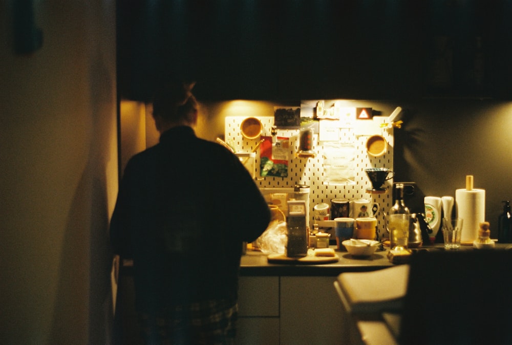 a man standing in a kitchen next to a refrigerator