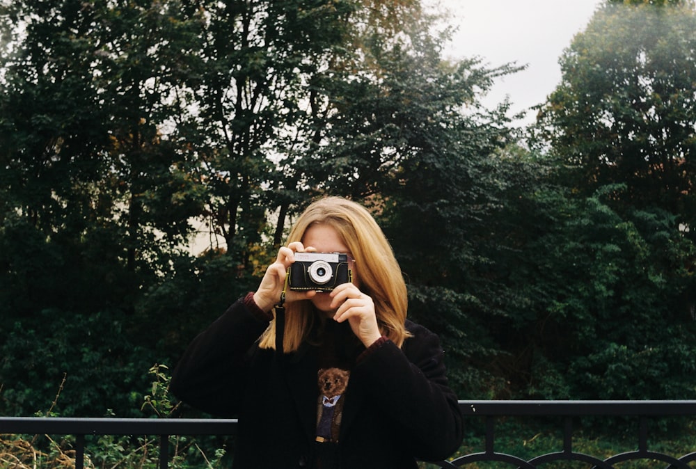 a woman taking a picture of herself with a camera