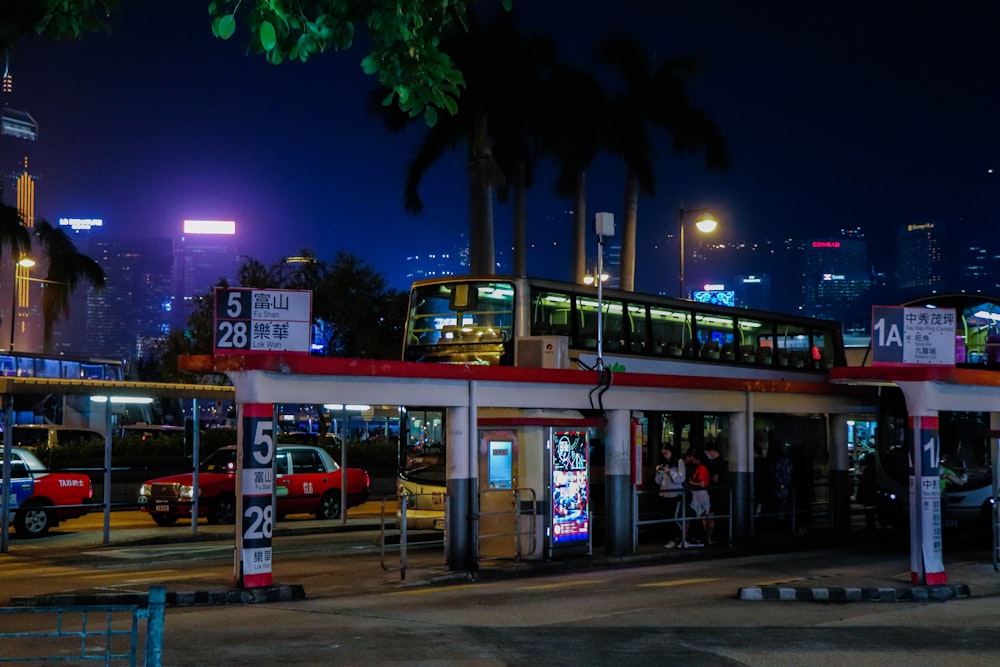 a double decker bus at a bus stop at night