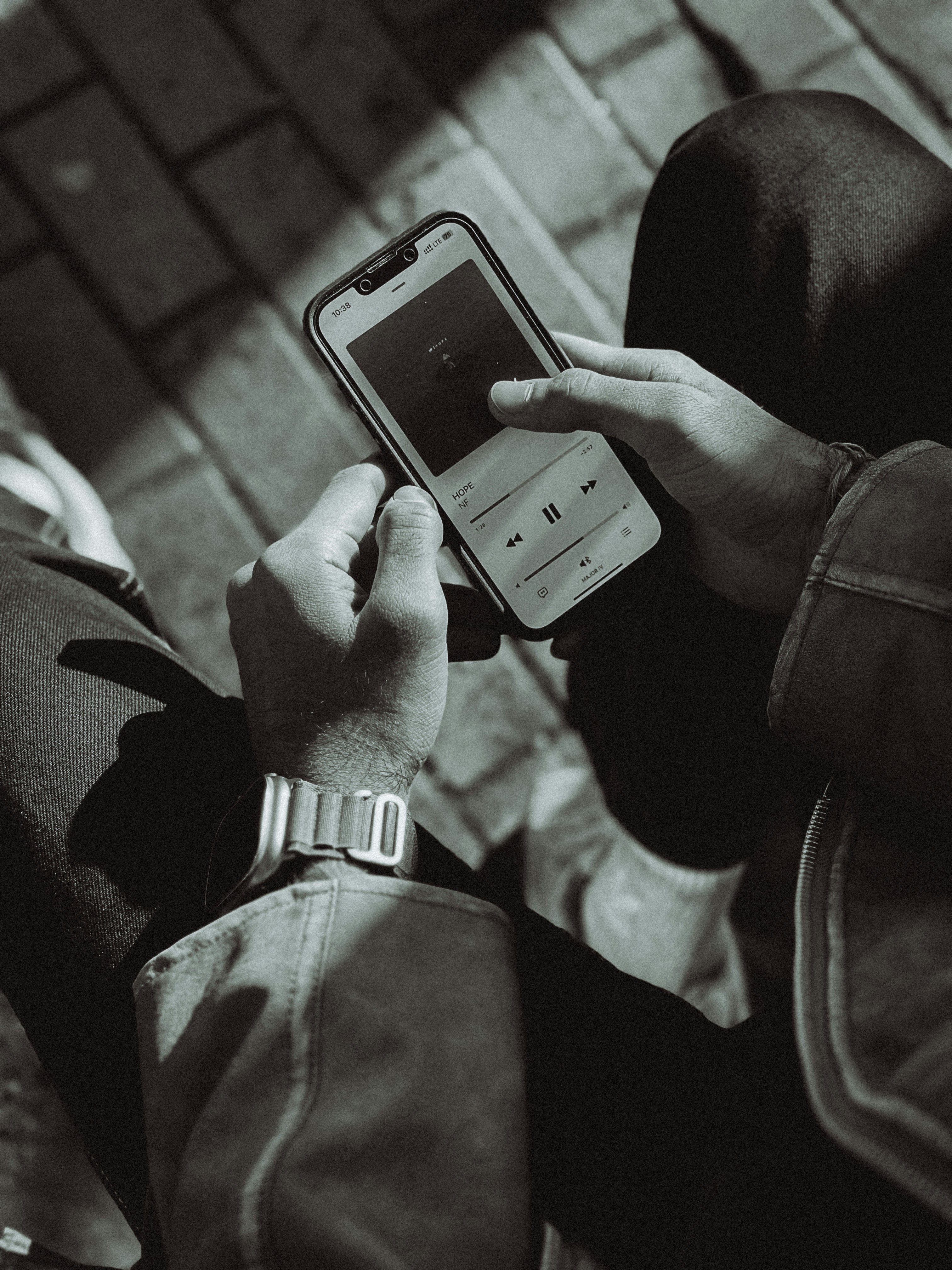 una foto in bianco e nero di una persona con in mano un telefono cellulare
