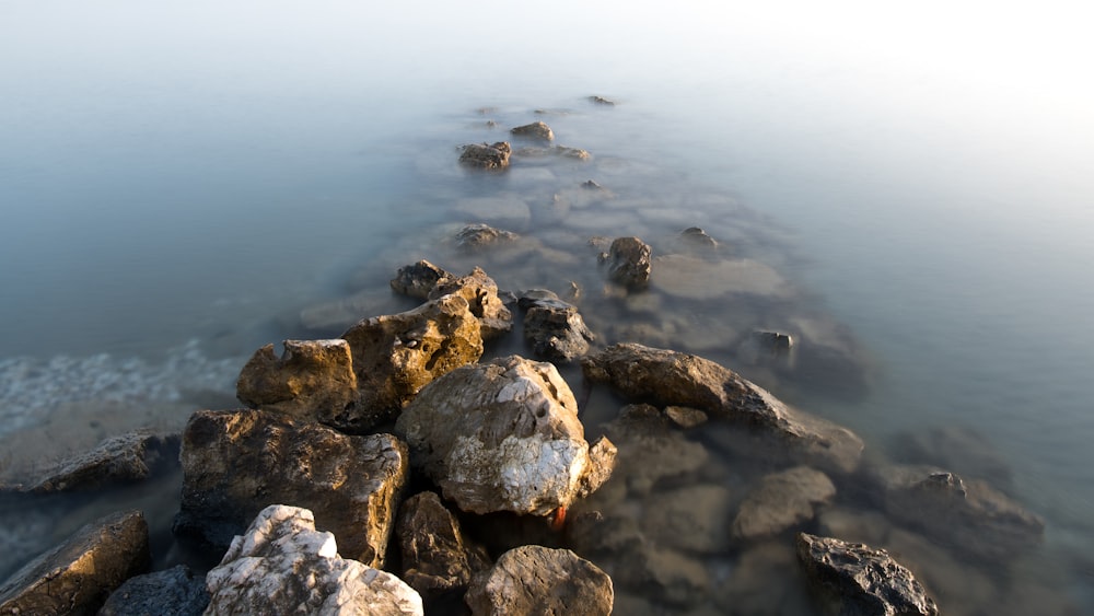 a long line of rocks sitting on top of a body of water