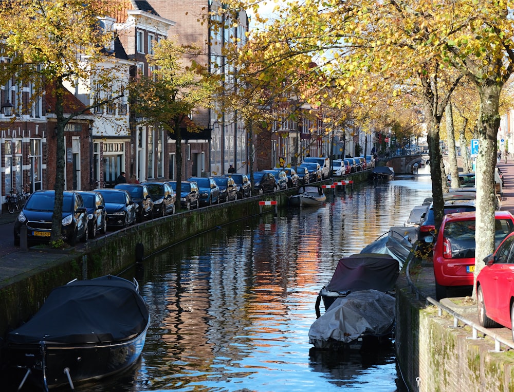 a canal filled with lots of boats next to tall buildings