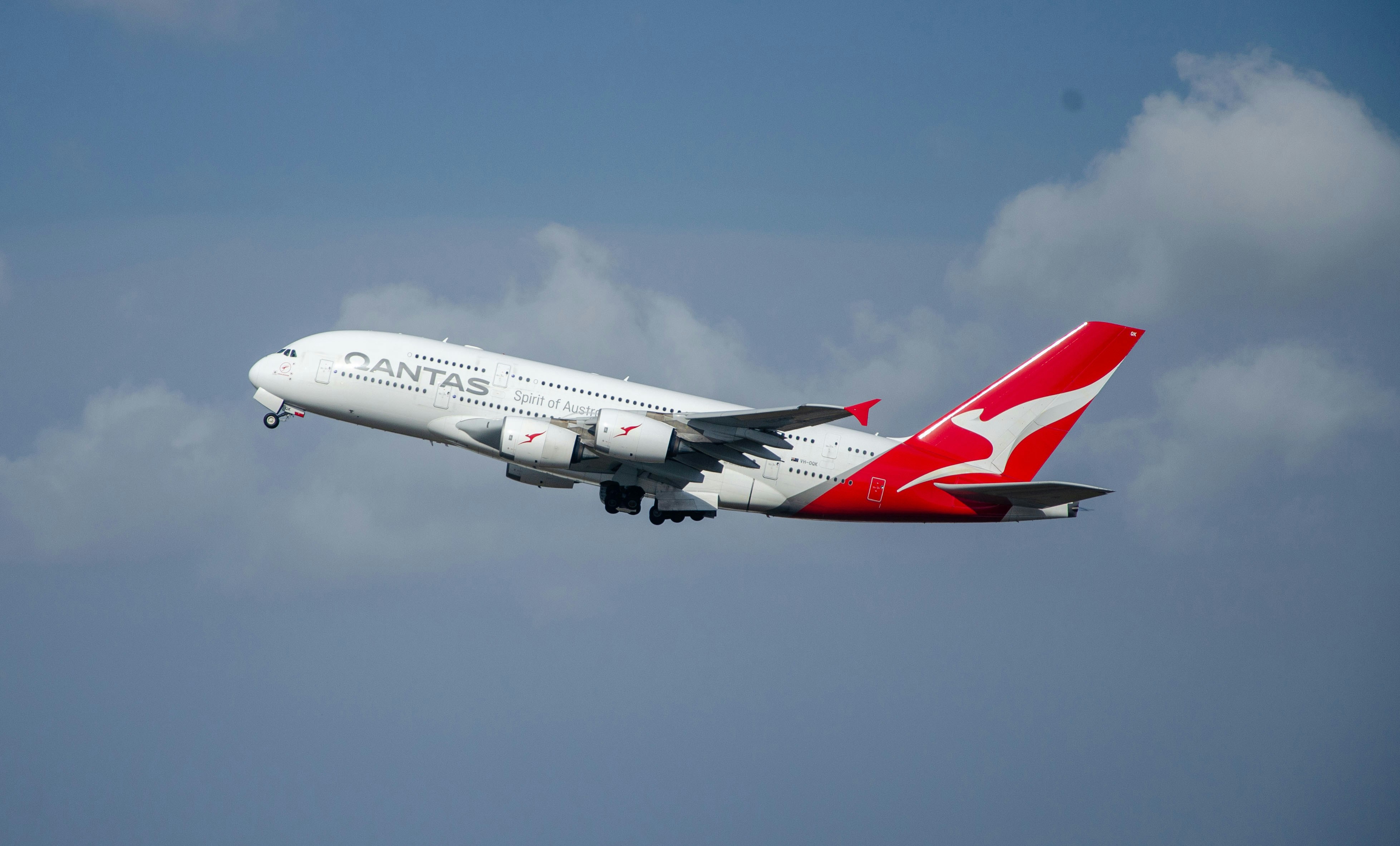 a large passenger jet flying through a cloudy blue sky, 