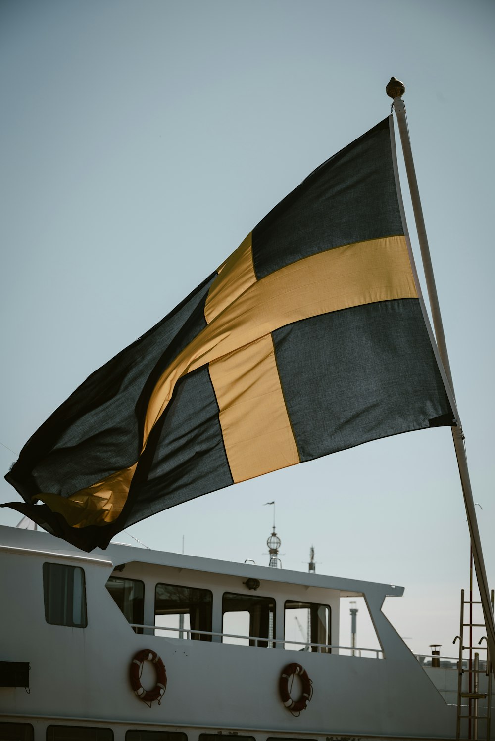 a large black and yellow flag on top of a boat