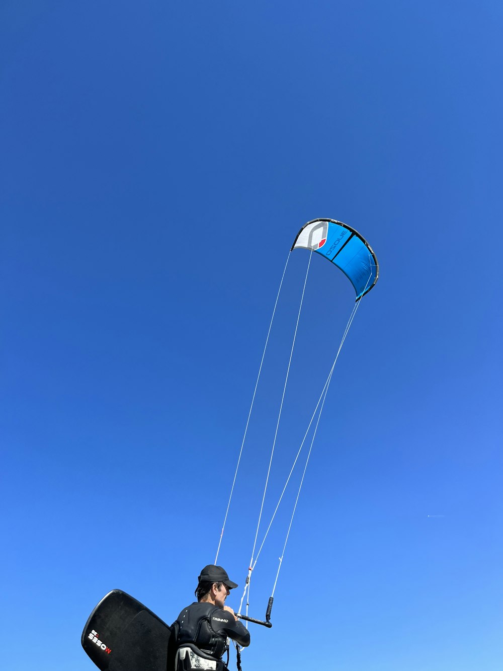 a man flying a kite in a blue sky