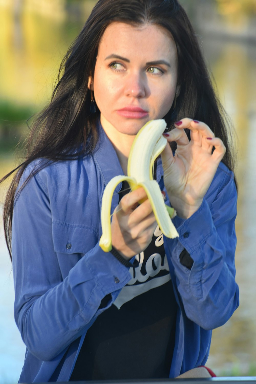 una mujer sosteniendo un plátano frente a su cara