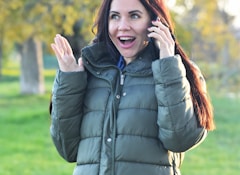 a woman in a park talking on a cell phone