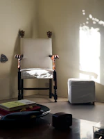 An elegant living room corner featuring a custom wooden chair with finely detailed carving and soft lighting.
