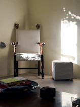 Sunlit corner of the first-floor room showing handcrafted furniture and cozy seating.