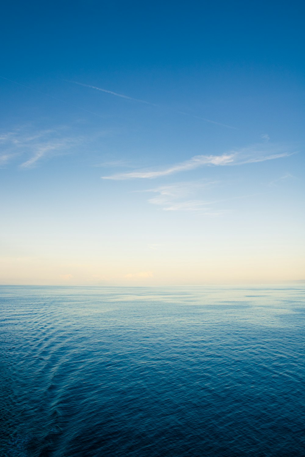 a large body of water sitting under a blue sky