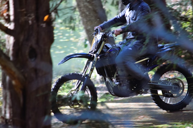 A dynamic dirt bike rider navigating a rugged off-road trail.