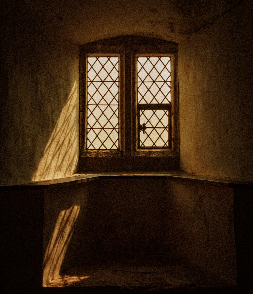 a window in a stone building with a light coming through the window