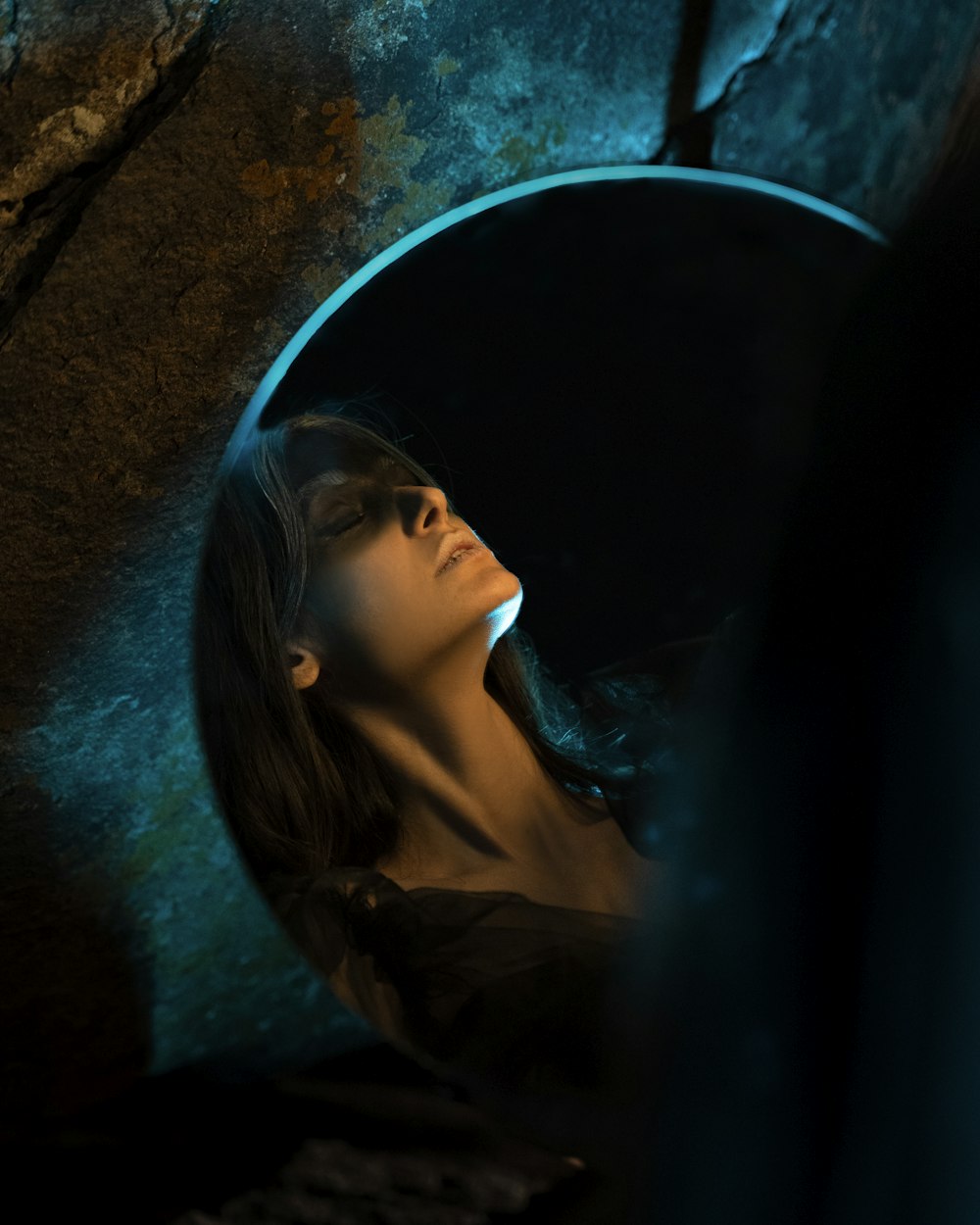 a woman with her eyes closed in a cave