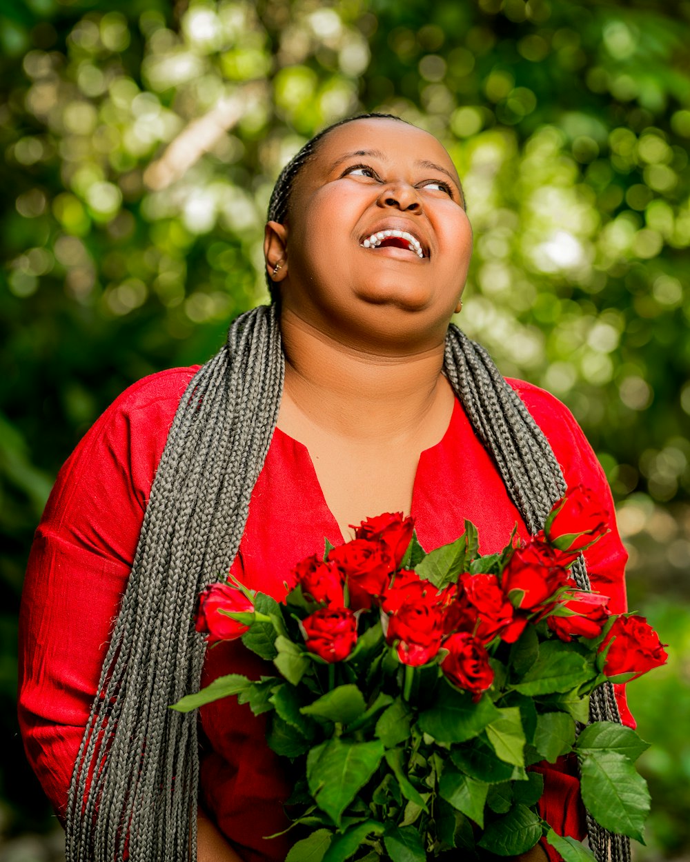 a woman holding a bouquet of red roses