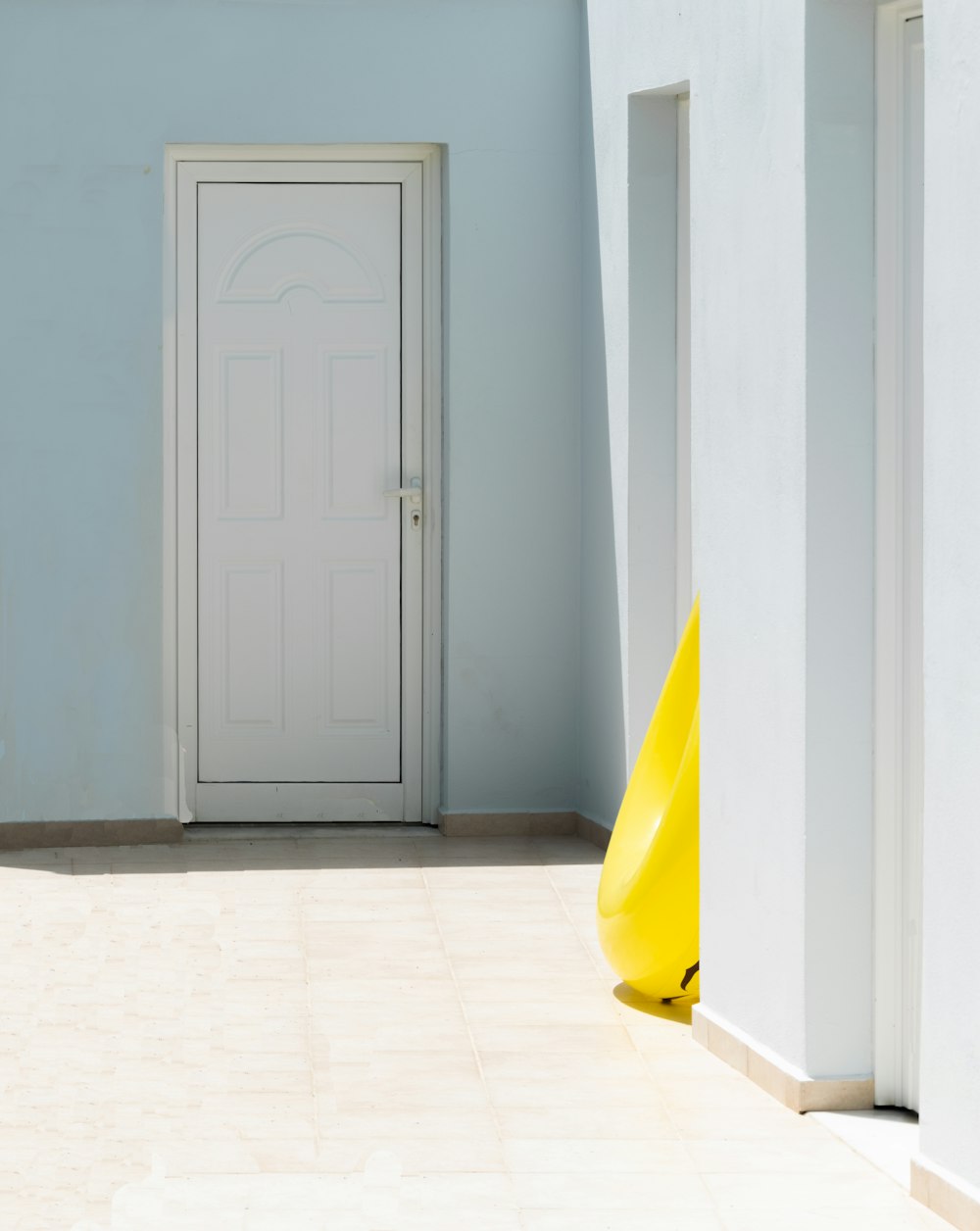 a room with a white door and a yellow cone on the floor