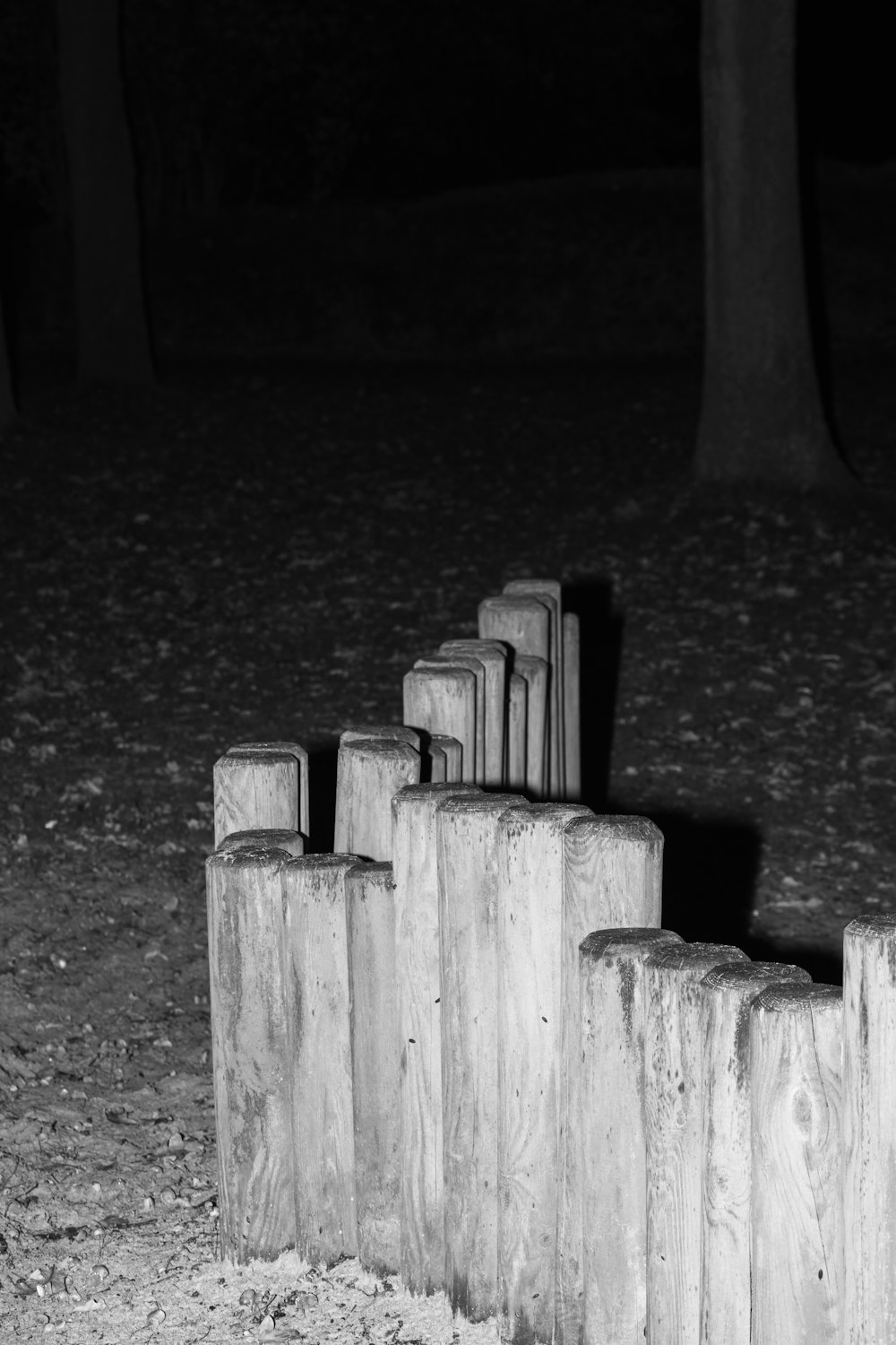 a black and white photo of a row of wooden posts