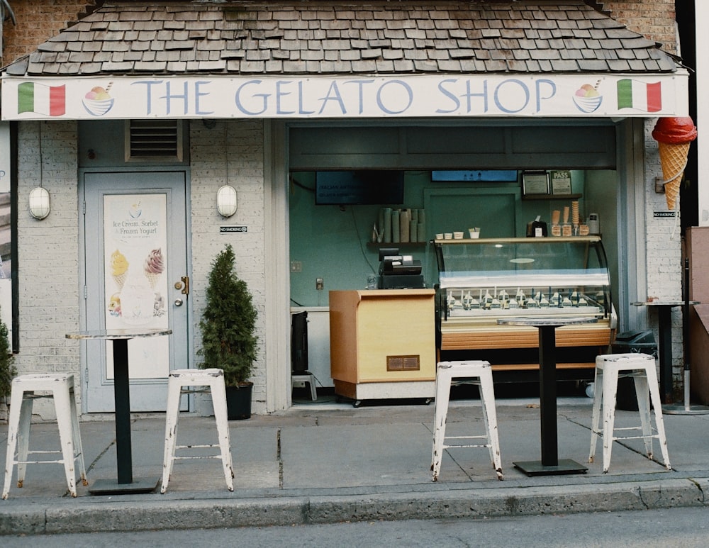 a store front with stools in front of it