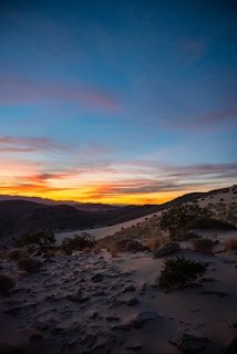 A scenic view of a desert landscape at sunset.