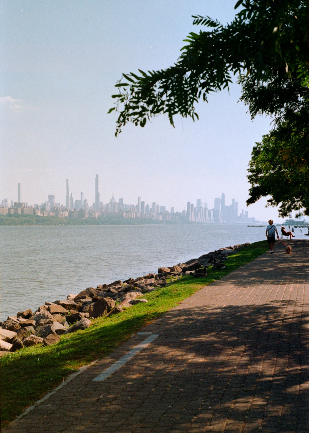 a man sitting on a bench next to a body of water