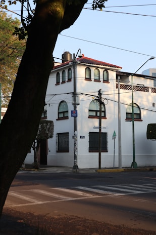 a white building with a red roof on a street corner
