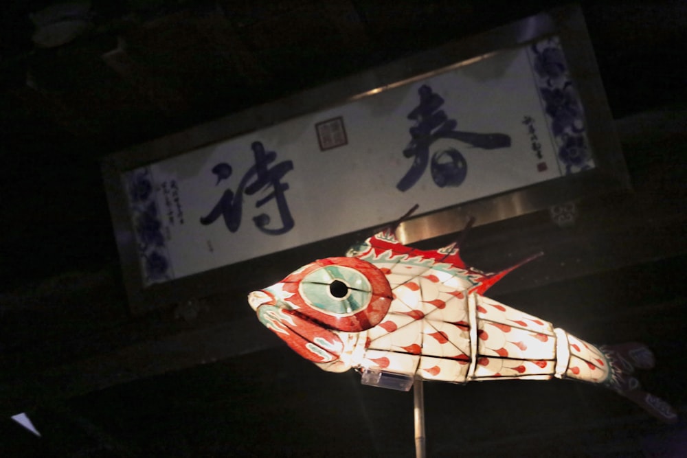 a paper fish is hanging on a pole