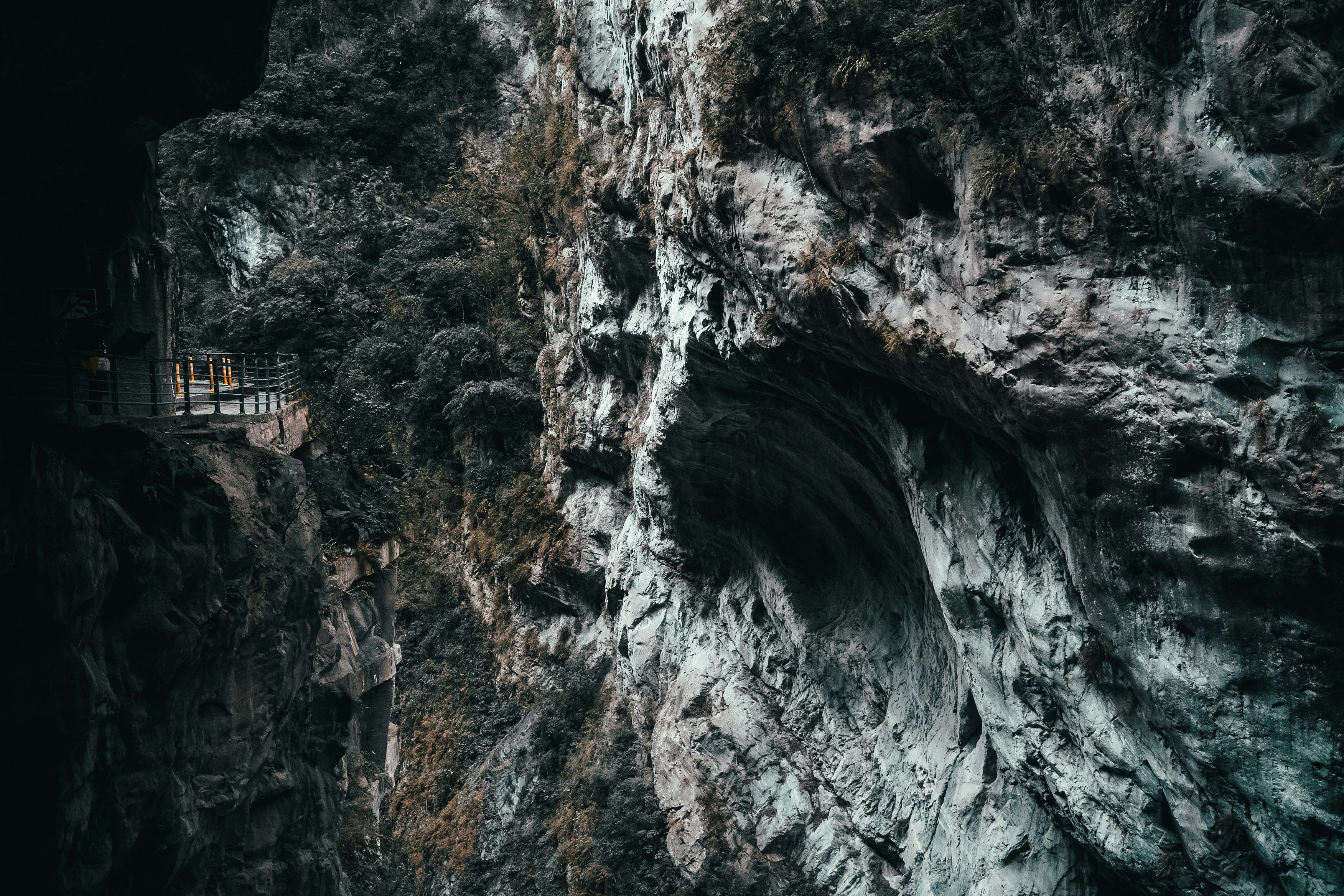 a man standing on a ledge in a cave, Side of a mountain, aftermath of earthquakes after earthquakes. Mountain sides of such engraving makes this spot a must go.