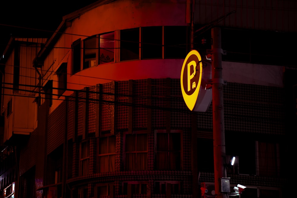 a yellow and black street sign on a pole next to a building