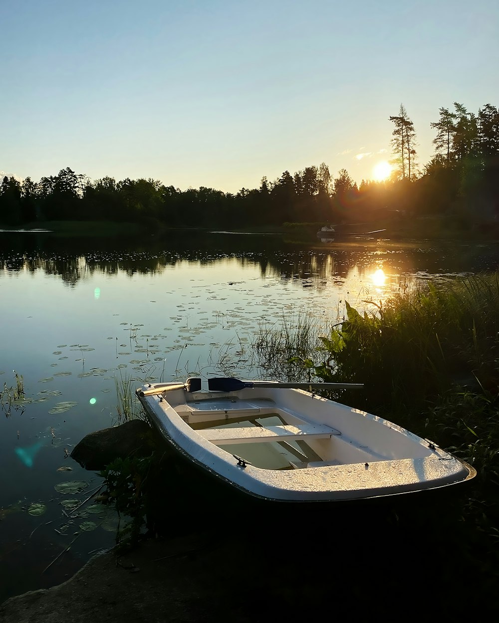 a small boat sitting on the shore of a lake