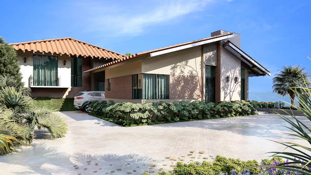 A modern luxury home exterior with warm terracotta accents under a clear blue sky.