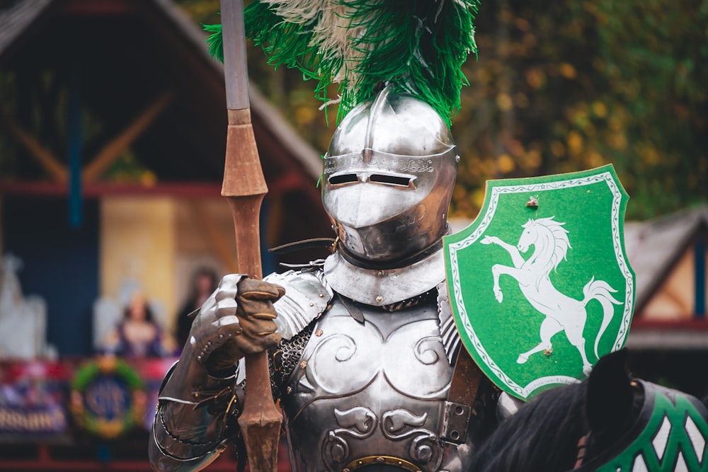 a man dressed in armor and holding a green shield
