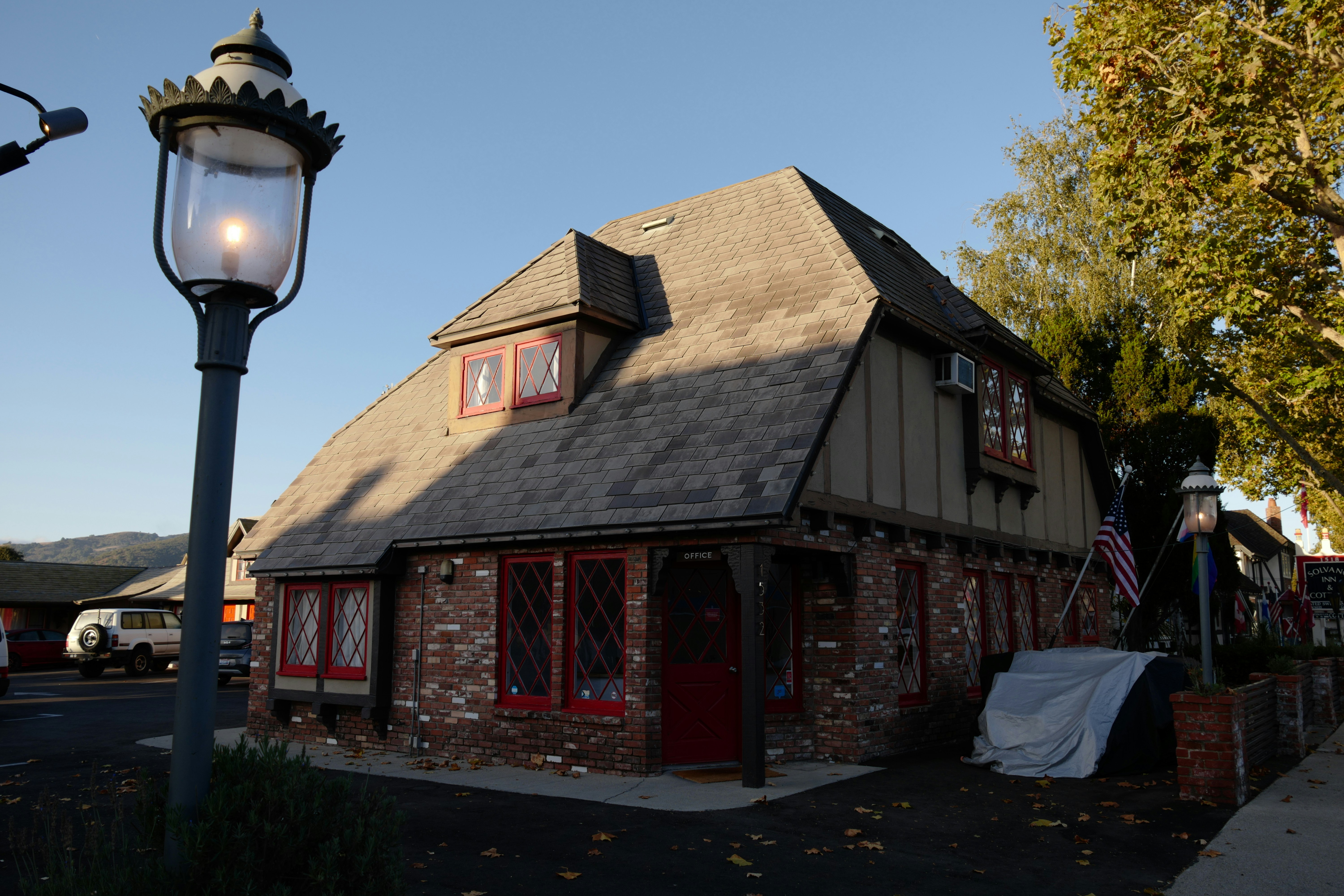 a brick building with a red door and a black roof