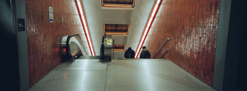 an escalator in a building with red lights